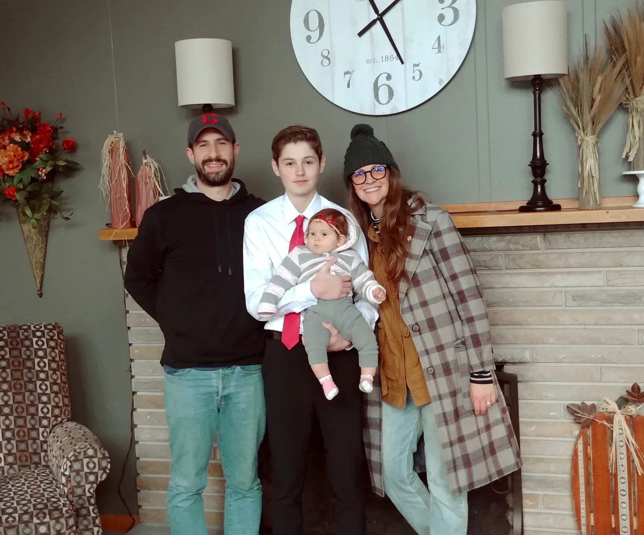 Parents and children gathered at home with their new baby