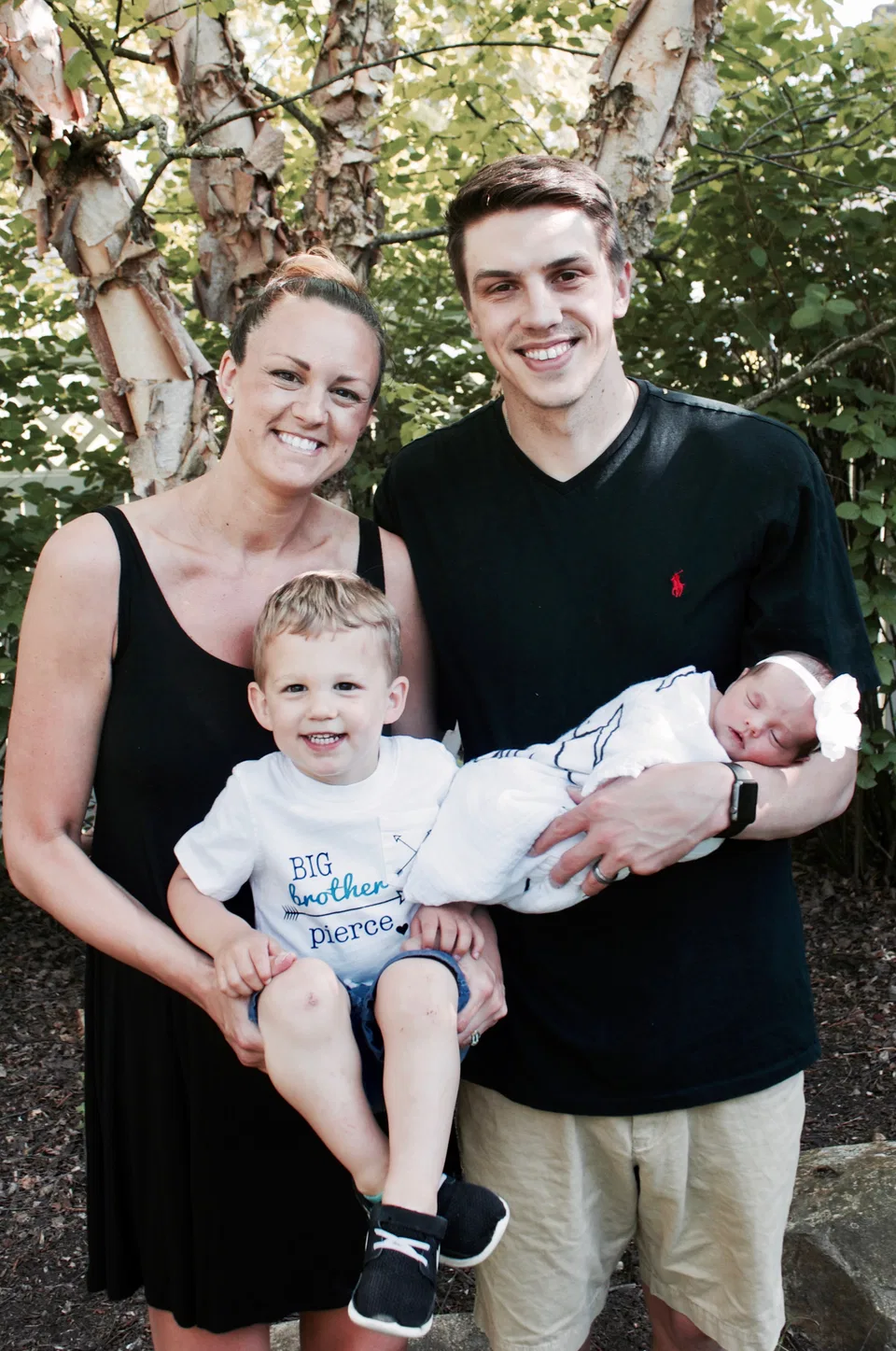 A Northeast Ohio family holding their baby and older child outdoors