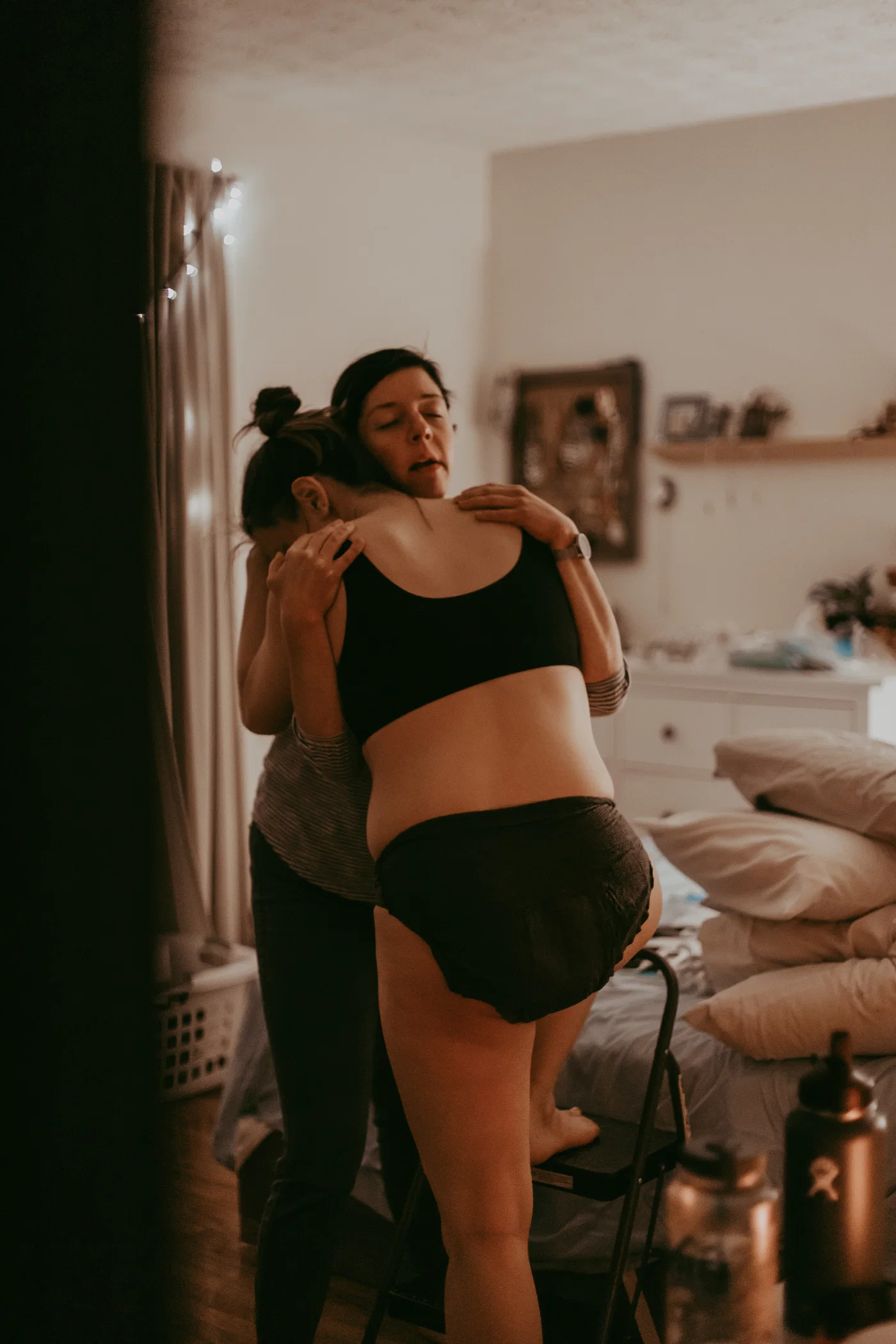 A support person embracing a laboring mother at home